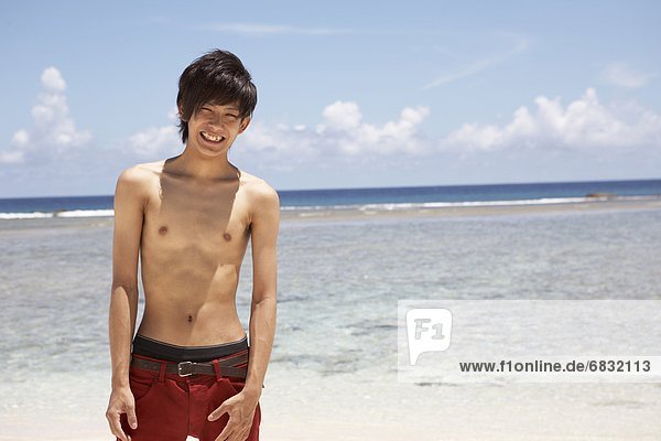 Portrait of young man standing on beach  Guam  USA