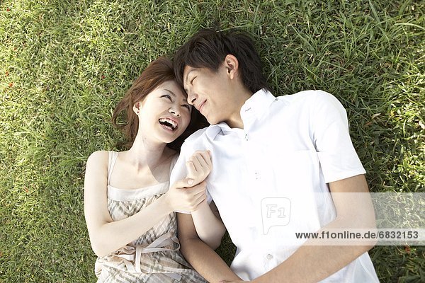 Couple lying down on grass  Guam  USA