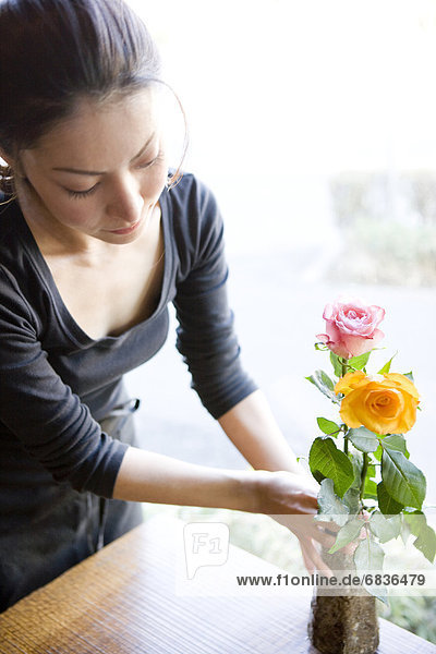 Young Woman Arranging Flower in Vase