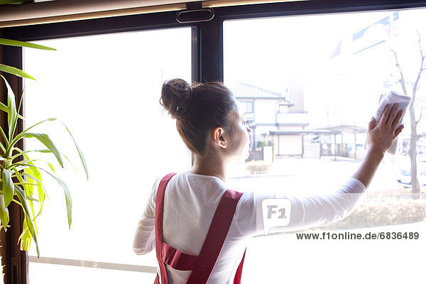 Young Woman Wiping Window