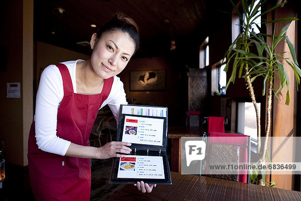 Mid Adult Woman Showing Menu at Table