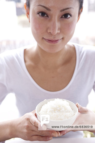Frau  halten  Reis  Reiskorn  jung  Tisch