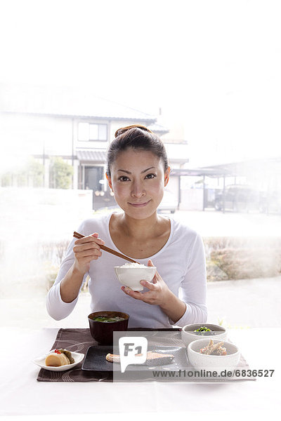 Young Woman Eating Japanese Cuisine