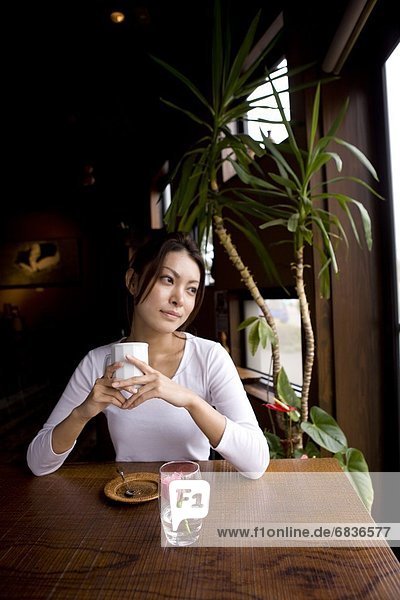 Woman at a cafe holding cup of coffee
