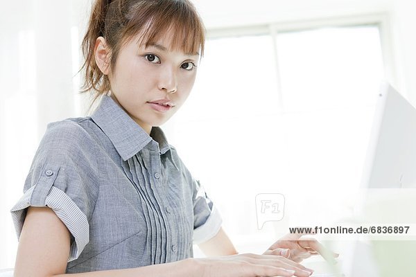 Young woman sitting at a desk and using a laptop