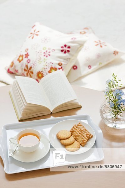 A book  cookies and orange juice on a living room table