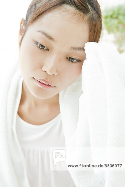 Young woman wearing a bathrobe and looking stressed