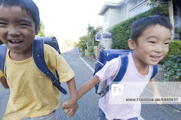 Boys holding hands and running  Tokyo Prefecture  Honshu  Japan
