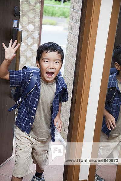 Boy arriving home from school  Japan