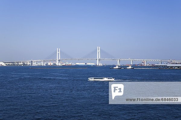 The Yokohama Bay Bridge and a sea bus in the harbor. Yokohama  Kanagawa Prefecture  Japan