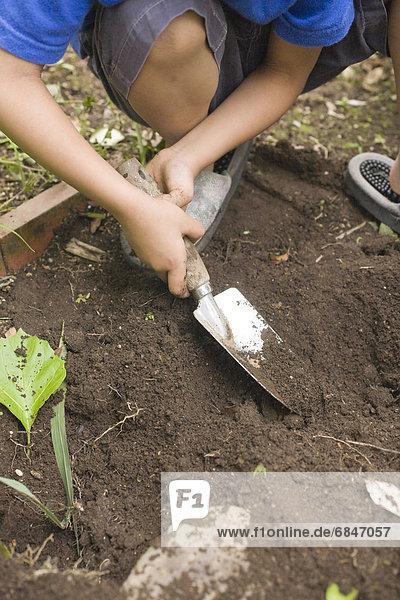 Boy with a shovel digging dirt  Kanagawa Prefecture  Honshu  Japan