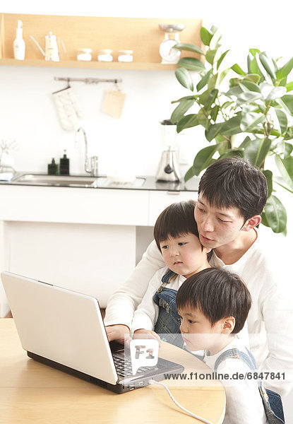 Father and sons using laptop