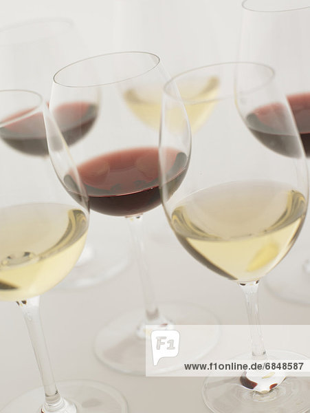 Glasses of red and white wine  close up  white background