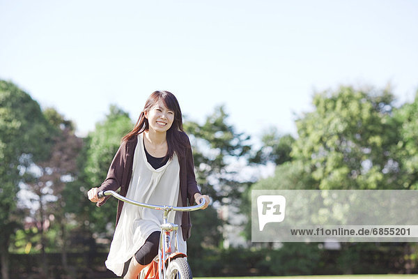 Young woman cycling at park  Japan