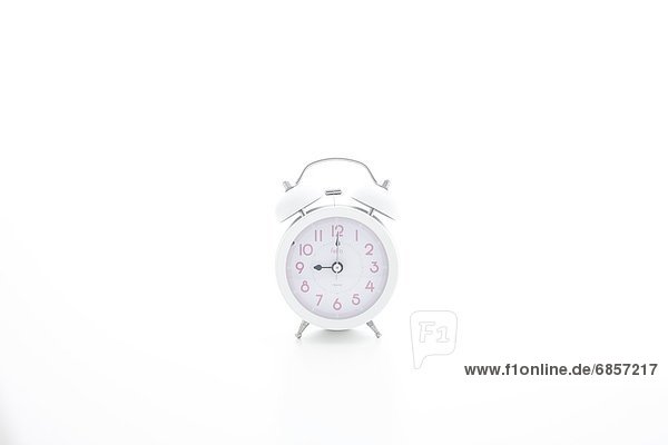 A single white alarm clock