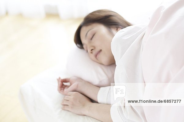 Young woman lying in bed asleep