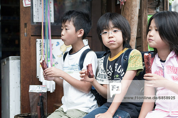 Kids eating traditional Japanese snacks Japan