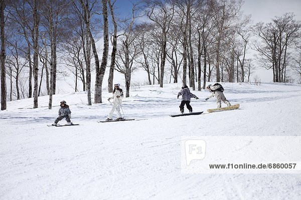 Familie Skifahren und Snowboarden