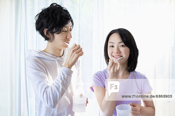 Young Couple Brushing Teeth