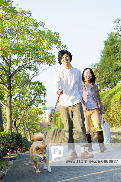 Young Couple Walking a Dog