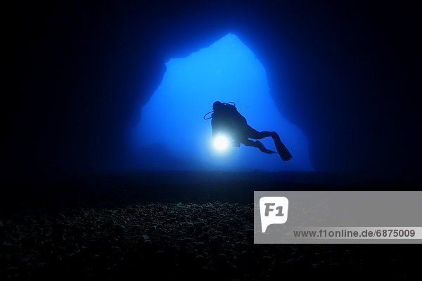 Diver in the entry of a cave  Mediterranean Sea near Gozo  Malta  underwater shot