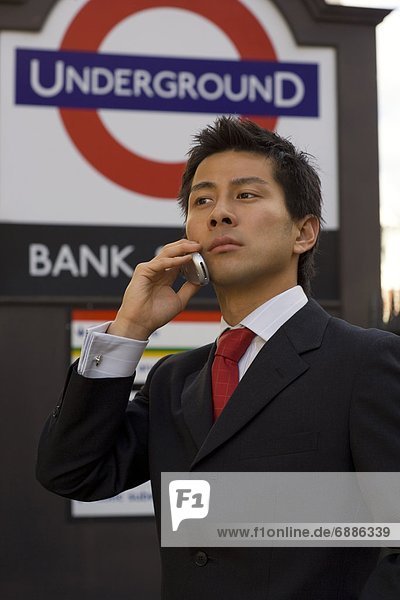 The businessman who applies a cellular phone at the subway entrance in London