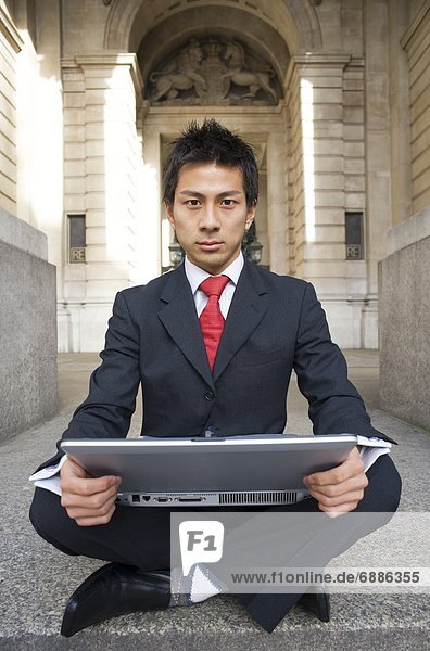 Businessman Using Laptop on Steps of Royal Exchange