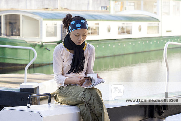 Young Woman Reading Magazine in Boat