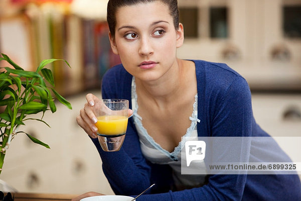 Junge Frau trinkt Orangensaft