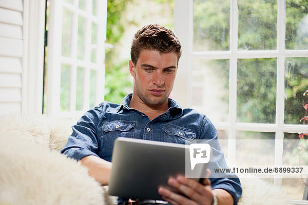 Junger Mann mit digitalem Tablett