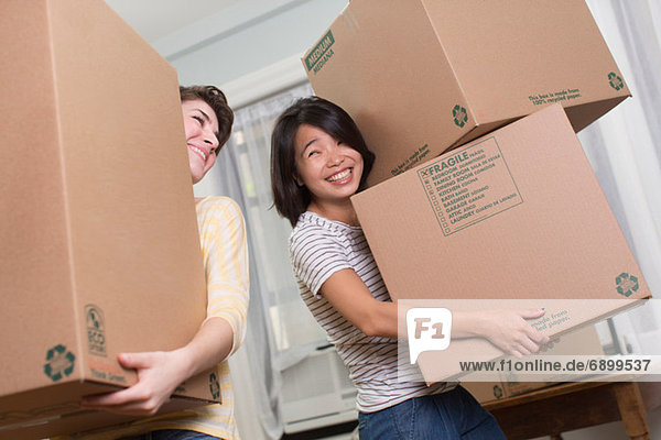 Zwei junge Frauen bewegen Kisten