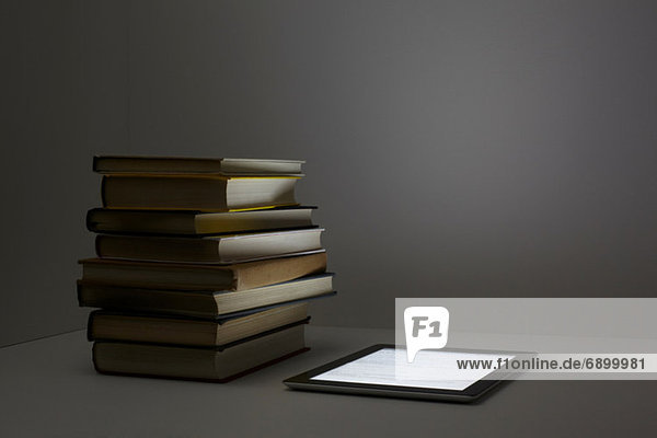 Bücherstapel mit digitalem Tablett