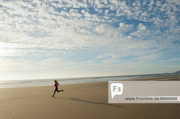 Junge Frau beim Laufen am Strand