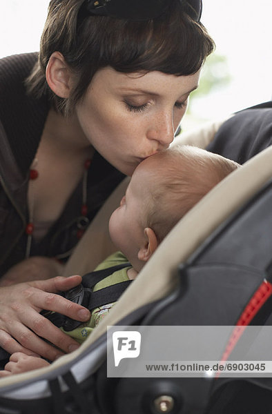 Mother Buckling Baby into Car Seat