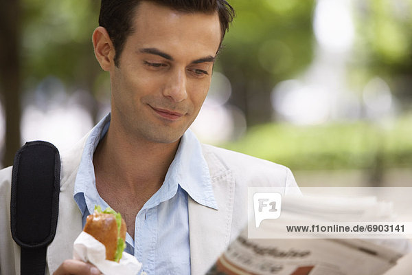 Mann  Sandwich  essen  essend  isst  Zeitung  vorlesen