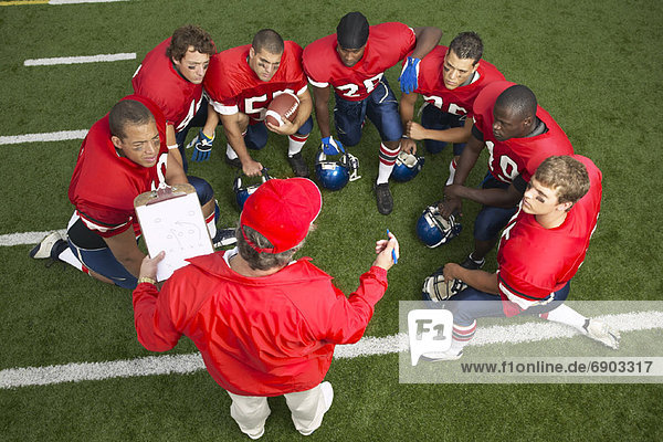 Coach Talking to Football Players in Huddle
