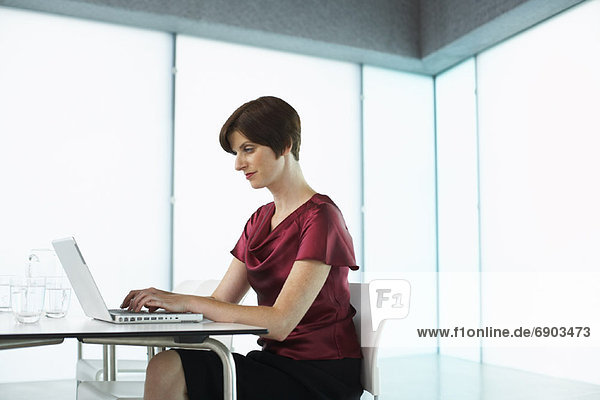 Woman with Laptop Computer in Boardroom