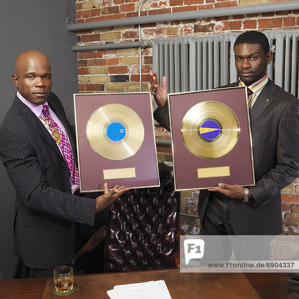 Record Executives Holding Gold Records