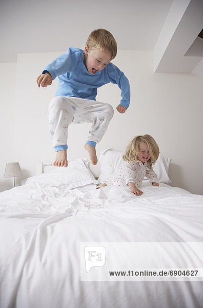 Kinder springen auf Bett