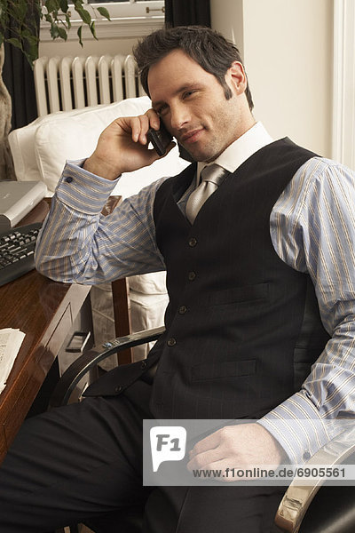 Businessman at Desk with Cellular Phone