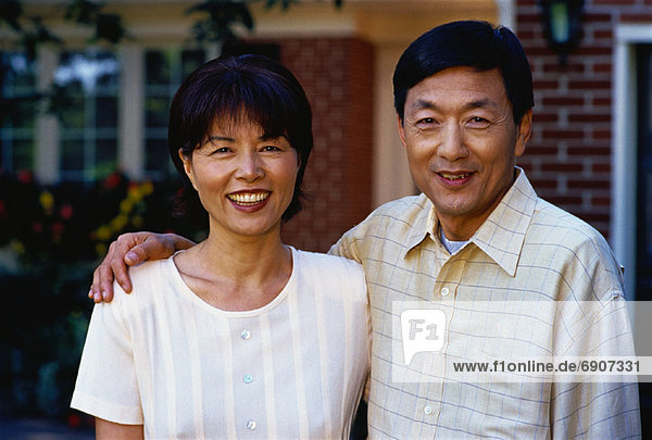 Portrait of Mature Couple Standing in Front of House
