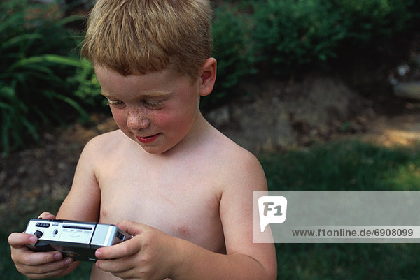 Boy Holding Camera Outdoors