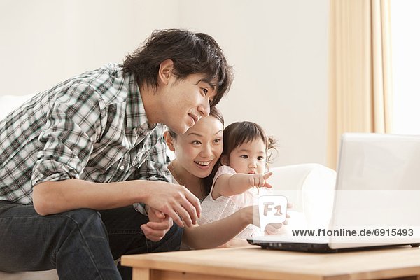 Mother  Father and Baby Girl Using Laptop