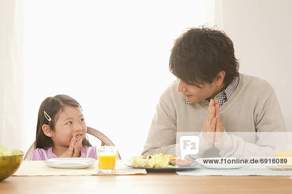 Father and Daughter Praying at Breakfast Table