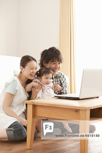 Parents and Baby Girl Using Laptop