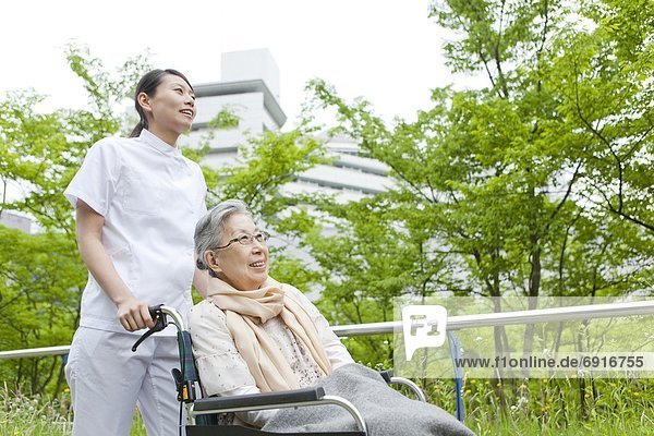 Nurse Pushing Senior Woman in Wheelchair