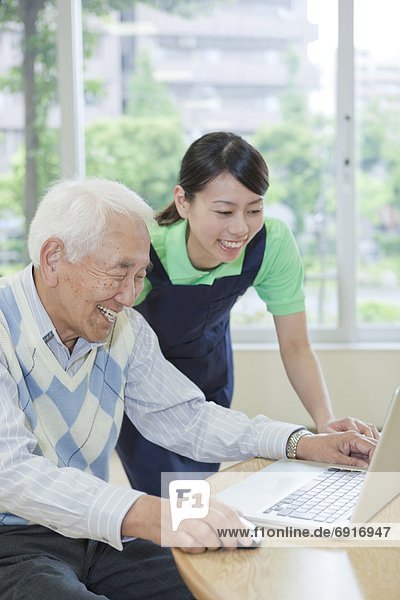 Senior man and nurse using a laptop  Kanagawa Prefecture  Honshu  Japan