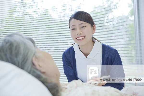 Nurse holding senior woman's hand  Kanagawa Prefecture  Honshu  Japan