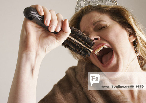 Woman Dressed Up  Singing Into Hair Brush