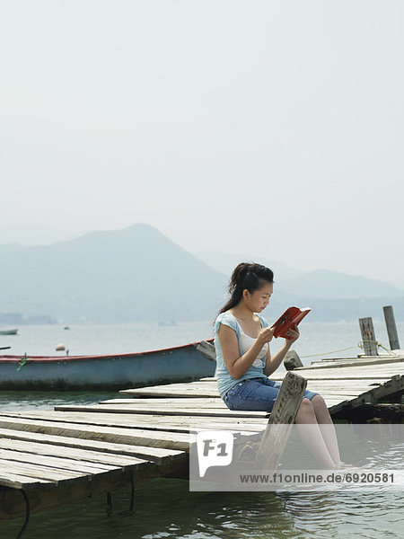 Woman Reading on Dock